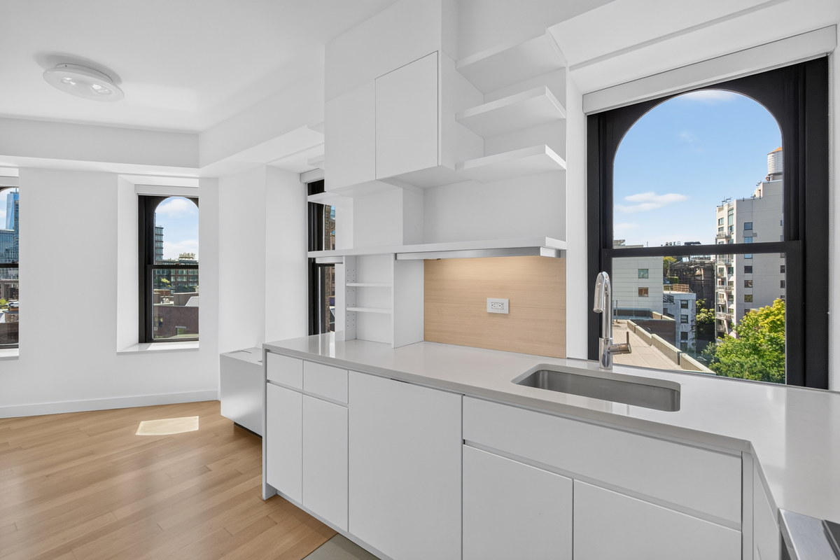 West Village apartment with arched window and minimal white kitchen