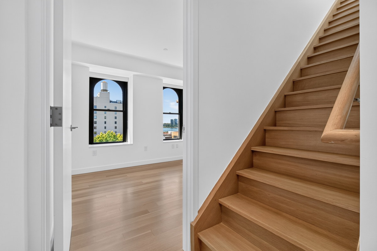 West Village apartment wood staircase with arched windows