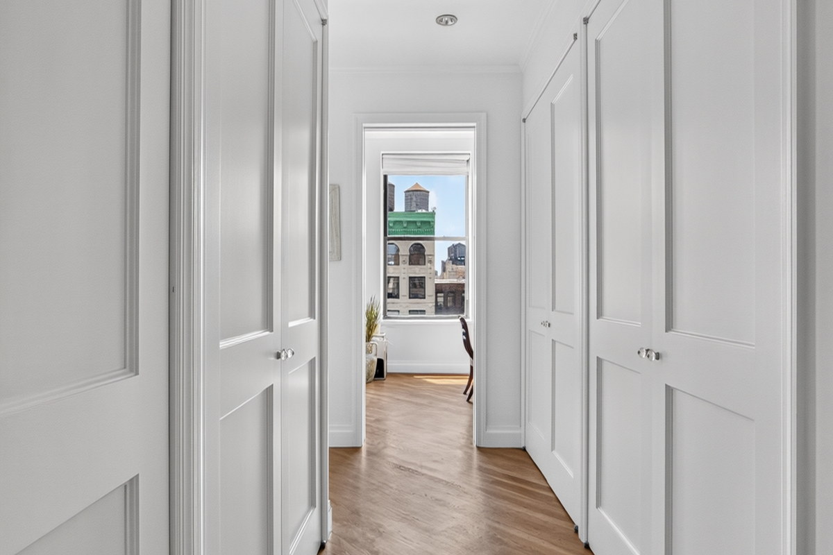 Hallway with paneled closet doors leading to room with water tower view